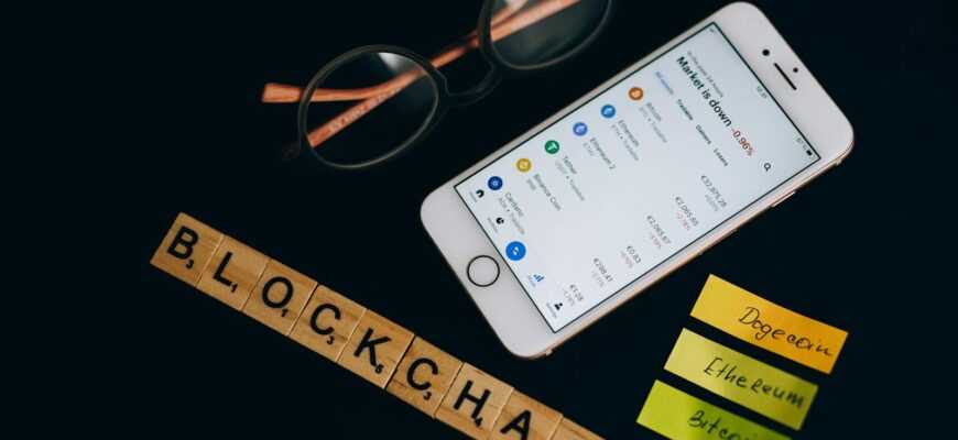 Smartphone displaying cryptocurrency market data alongside blockchain concept elements.