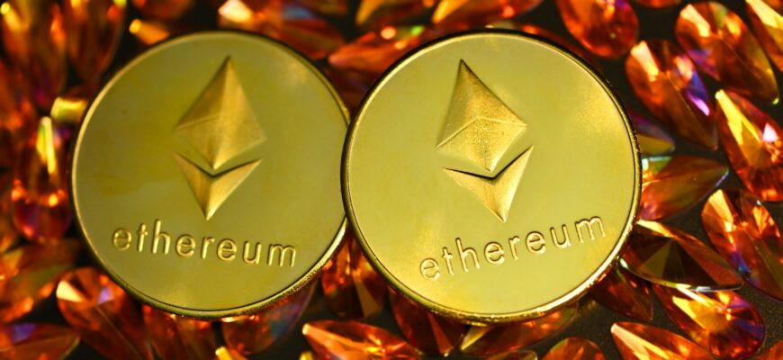 two gold ethereum tokens sitting on top of a pile of crystals