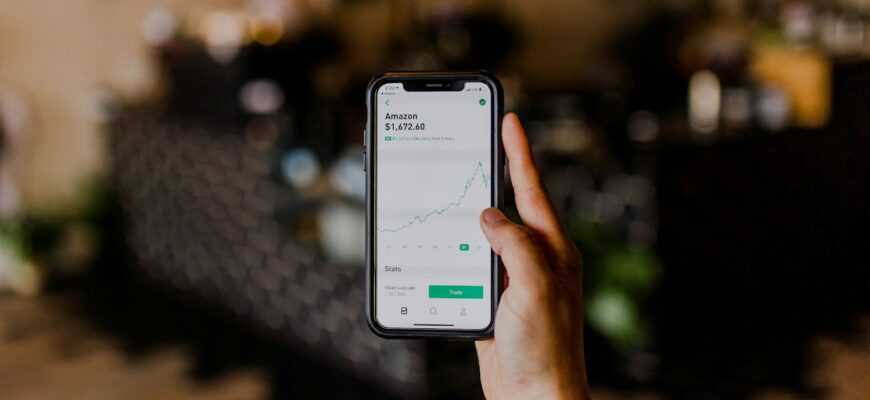 person holding black iPhone displaying stock exchange