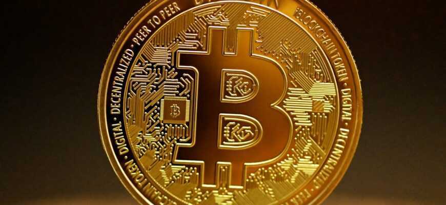 a golden bitcoin sitting on top of a table