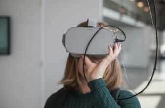 woman in black sweater holding white and black vr goggles