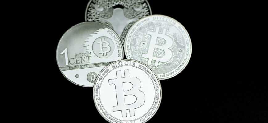 a pile of silver bitcoins sitting on top of each other